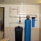 В состав системы водоподготовки входят: фильтр грубой очистки, универсальный фильтр для очистки воды (обезжелезиватель + умягчитель), фильтр тонкой очистки. Канализация и ввод воды в дом находятся за стенкой. 
